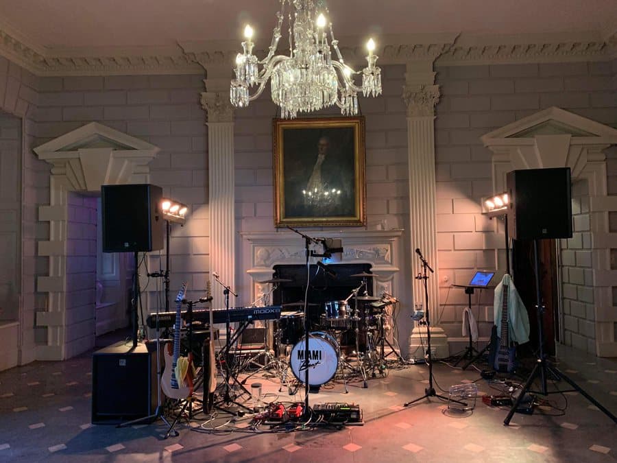 The band's stage set up in a panelled room at Davenport House, under a crystal chandelier beside a portrait over the fireplace
